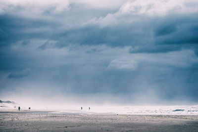 Few scattered people on the beach of the atlantic ocean on an overcast and foggy day 