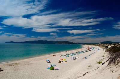 People at beach against sky