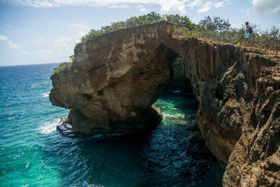 Rock formation in sea against sky