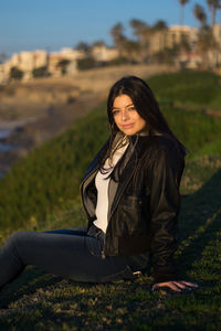 Young woman sitting on grassy field