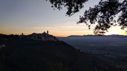 Scenic view of silhouette buildings against sky at sunset