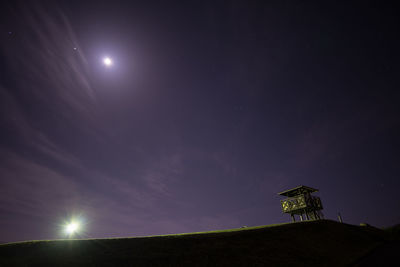 Low angle view of illuminated moon against sky at night