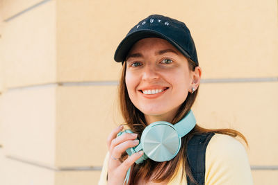 Portrait of smiling woman holding headphones