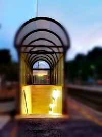 Illuminated light bulb against sky in city