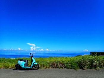 Bicycle sitting on road against clear blue sky