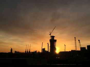 Silhouette of cranes at construction site