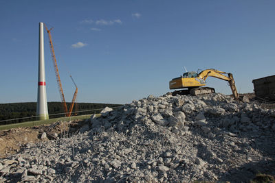 Construction site by road against sky