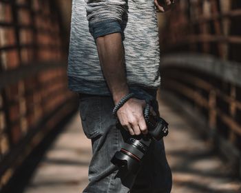 Midsection of man holding hands with camera