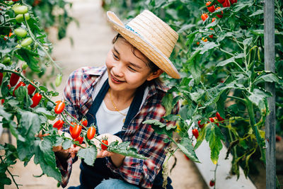 Portrait of young woman standing against plants