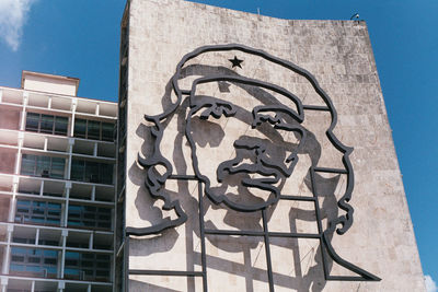 Low angle view of graffiti on building against sky