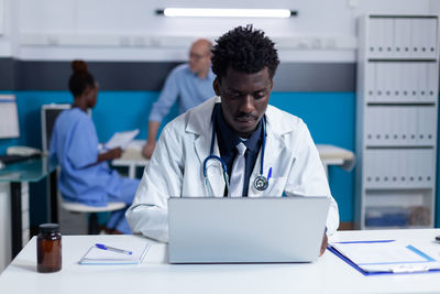 Male doctor using laptop at clinic