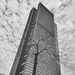 Low angle view of skyscraper against cloudy sky