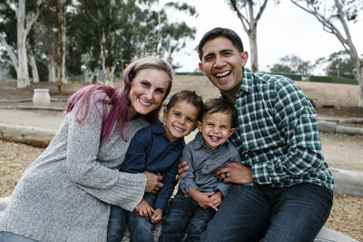 Portrait of happy family sitting at park