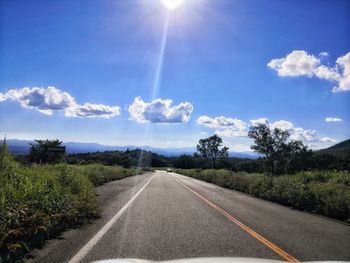 Road amidst plants against sky