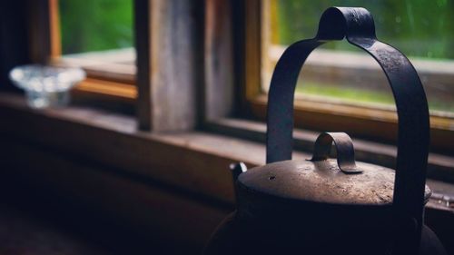 Close-up of kettle by window