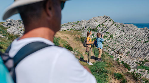 Rear view of people on mountain against sky