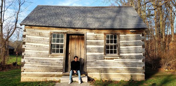 Front view of men sitting against old house