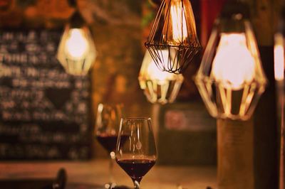 Red wine below illuminated lights in restaurant
