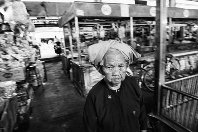 Portrait of senior woman standing at market in city