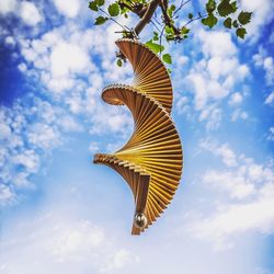 Low angle view of butterfly on tree against sky