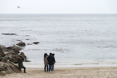 People on beach against sky