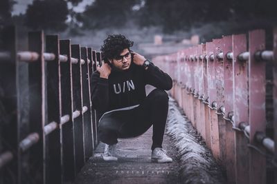 Full length of young man standing by railing