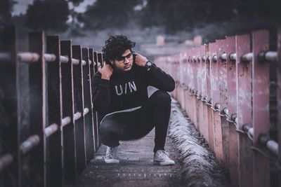 Full length of young man standing by railing