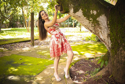 Full length of woman standing by tree