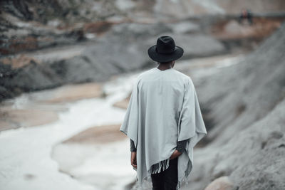 Rear view of man standing on snow covered land