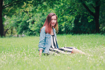 Young woman using mobile phone in grass