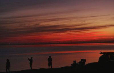 Silhouette people on beach during sunset