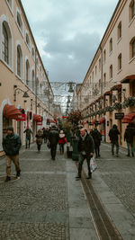 People on street against buildings in city