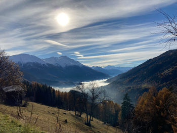 Scenic view of mountains and fog in the valley against sun with veil clouds. fieschertal switzerland