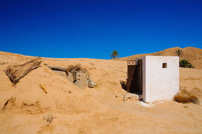 Scenic view of desert against clear blue sky