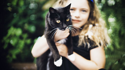 Portrait of woman with black cat