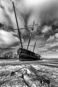 Sailboat on sea shore against sky