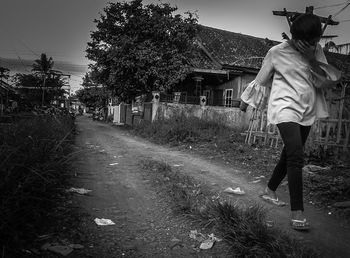 Rear view of man walking on road