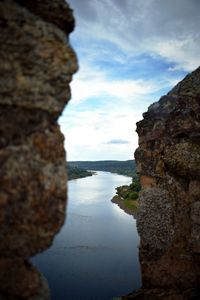 Rock formation by sea against sky