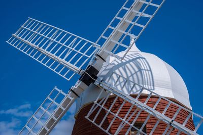 Low angle view of traditional windmill against clear blue sky