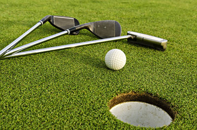 Golf club and ball on field