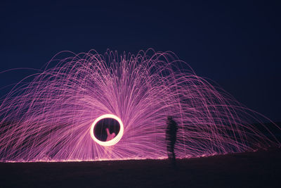 Low angle view of illuminated fireworks against sky at night