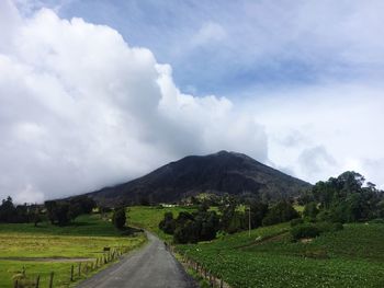 Road leading towards mountains against sky