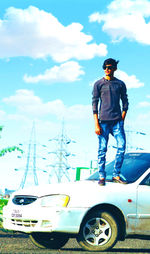 Full length of man standing by car against sky