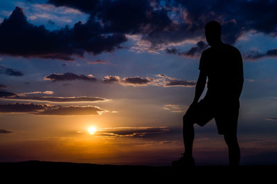 Silhouette man standing in front of mountain during sunset