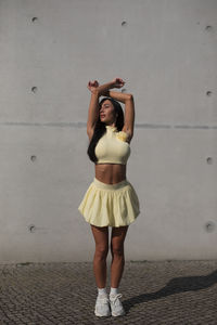 Full length of woman standing against wall