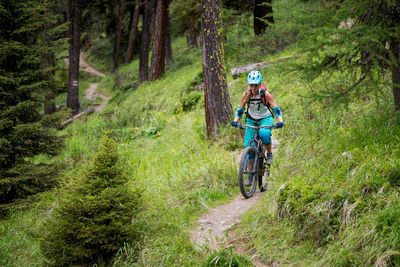 Woman riding bicycle at forest