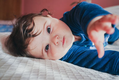 Portrait of cute baby girl on bed at home