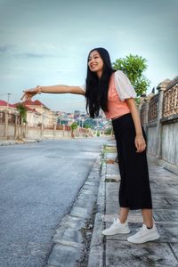 Full length of woman standing on road in city