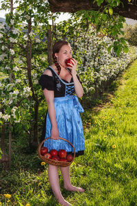 Portrait of smiling young woman standing against plants