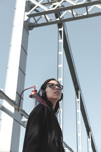 Low angle view of young woman against sky